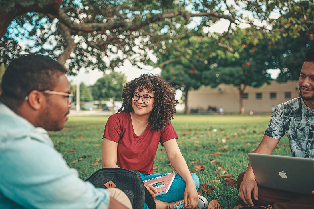 des étudiants assis sur l'herbe