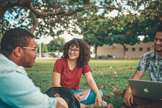 des étudiants assis sur l'herbe